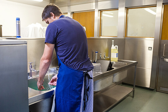 Bild Nebenjob als Küchenhilfe – Das Spülen von Töpfen, Pfannen, Geschirr, Gläsern und Besteck gehört zu den Aufgabenbereichen von Küchenhilfen.
